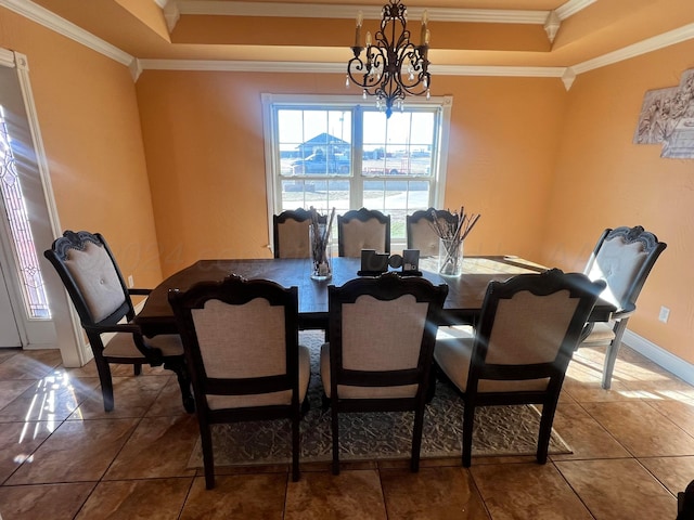 tiled dining room with a raised ceiling, crown molding, and a chandelier