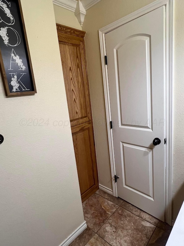 hall with tile patterned floors and ornamental molding