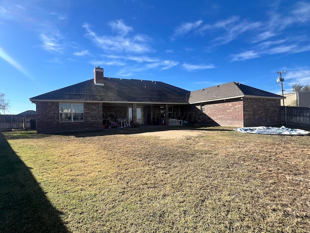 rear view of property with a lawn and central AC unit