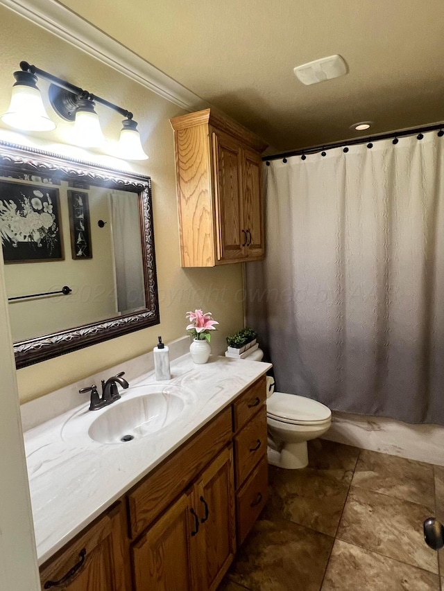 bathroom with tile patterned floors, vanity, toilet, and ornamental molding