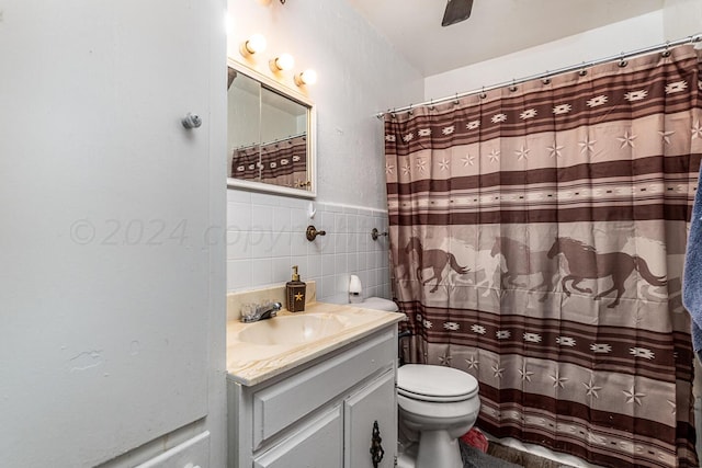 bathroom with walk in shower, vanity, toilet, and tile walls