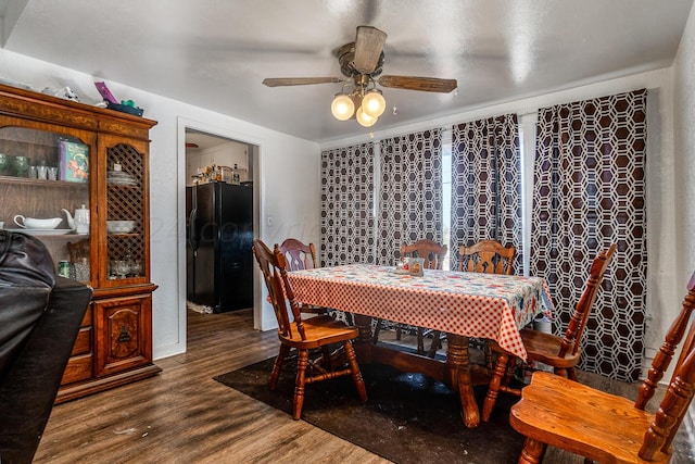 dining space with dark wood-type flooring and ceiling fan