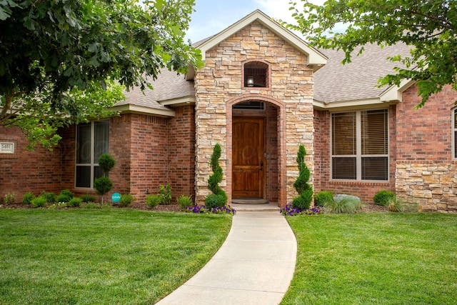 5401 Walesa Ct, Amarillo, TX 79119 - entrance to property with roof with shingles, stone siding, a lawn, and brick siding