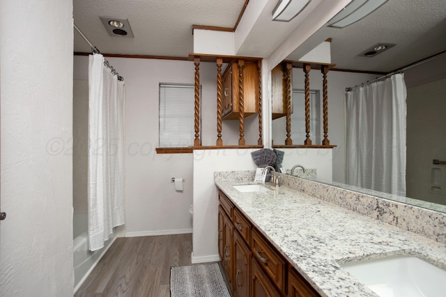 7408 Sleepy Hollow Blvd, Amarillo, TX 79121 - full bath featuring a textured ceiling, wood finished floors, double vanity, baseboards, and shower / tub combo with curtain