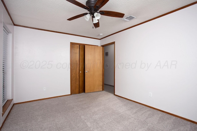 7408 Sleepy Hollow Blvd, Amarillo, TX 79121 - unfurnished bedroom with light colored carpet, crown molding, a textured ceiling, baseboards, and a closet
