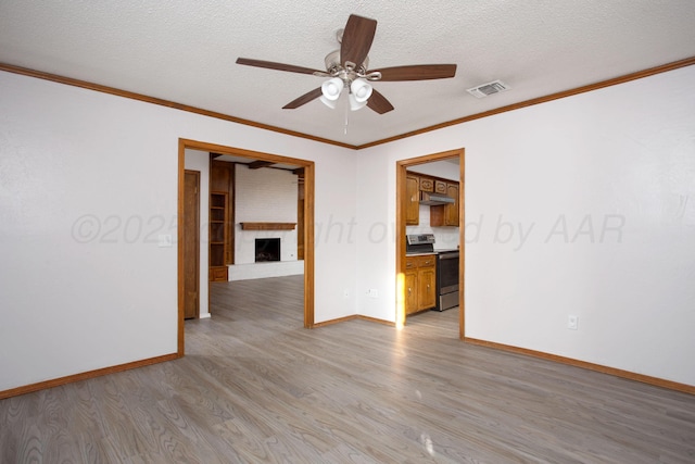 7408 Sleepy Hollow Blvd, Amarillo, TX 79121 - empty room featuring a fireplace, light wood-type flooring, baseboards, ceiling fan, and crown molding