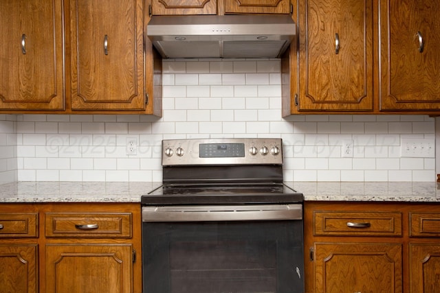 7408 Sleepy Hollow Blvd, Amarillo, TX 79121 - kitchen with electric stove, under cabinet range hood, brown cabinets, and decorative backsplash