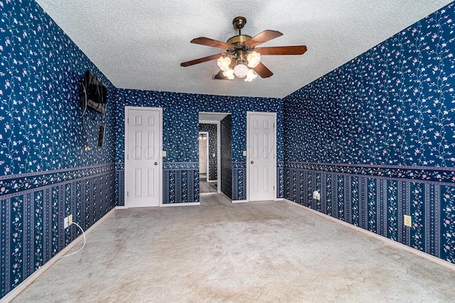 2723 County Road O, Friona, TX 79035 - unfurnished room featuring wallpapered walls, ceiling fan, a textured ceiling, and carpet flooring