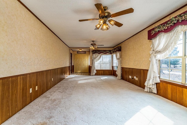 2723 County Road O, Friona, TX 79035 - unfurnished room featuring wooden walls, wainscoting, carpet floors, a ceiling fan, and ornamental molding