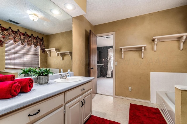 2723 County Road O, Friona, TX 79035 - full bath with a textured ceiling, a bath, vanity, tile patterned floors, and baseboards