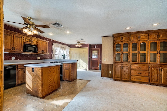 2723 County Road O, Friona, TX 79035 - kitchen with black appliances, ceiling fan, brown cabinets, a kitchen island, and a textured ceiling