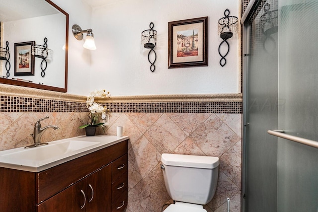 402 Beach Ave, Friona, TX 79035 - bathroom with vanity, toilet, a wainscoted wall, tile walls, and an enclosed shower
