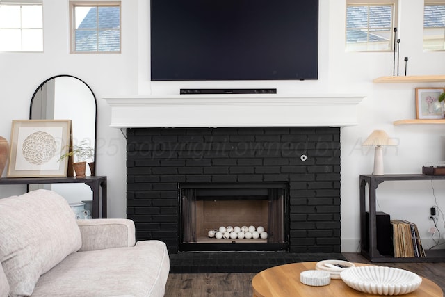 interior space with a brick fireplace and hardwood / wood-style floors