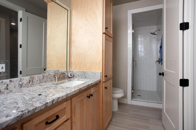 bathroom with toilet, vanity, and walk in shower