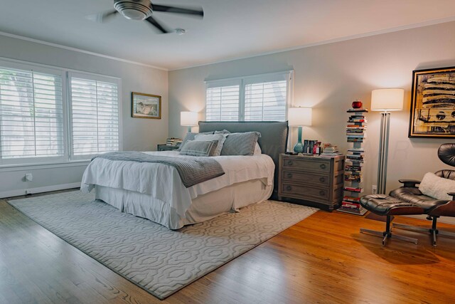 bedroom featuring crown molding, light wood-type flooring, a ceiling fan, and baseboards