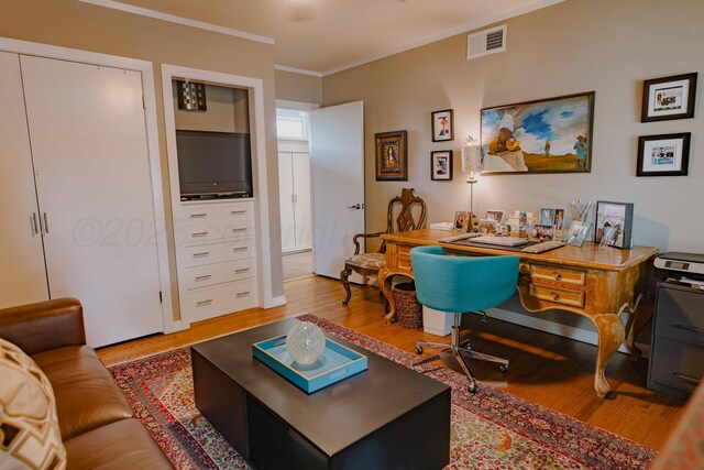 home office with wood finished floors and ornamental molding