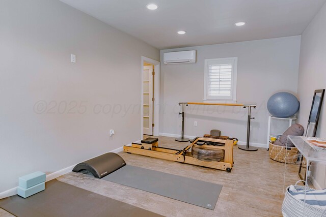 exercise area featuring baseboards, recessed lighting, a wall mounted air conditioner, and wood finished floors