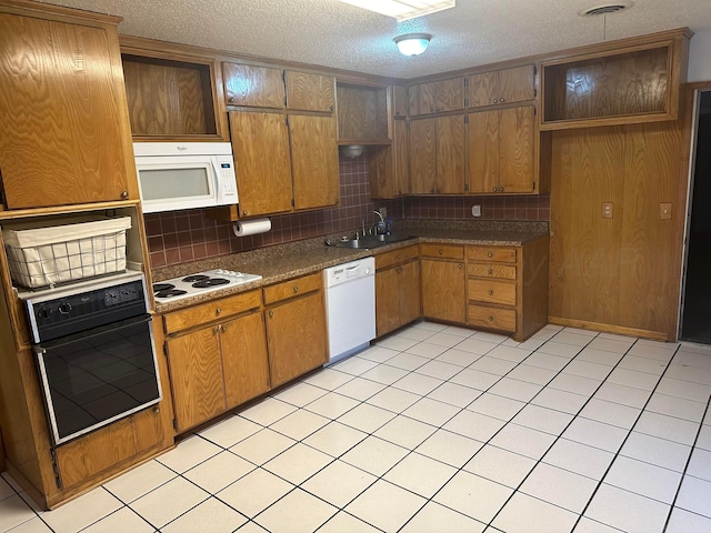 2810 Willbur Dr, Amarillo, TX 79110 - kitchen with white appliances, a textured ceiling, decorative backsplash, dark countertops, and brown cabinets