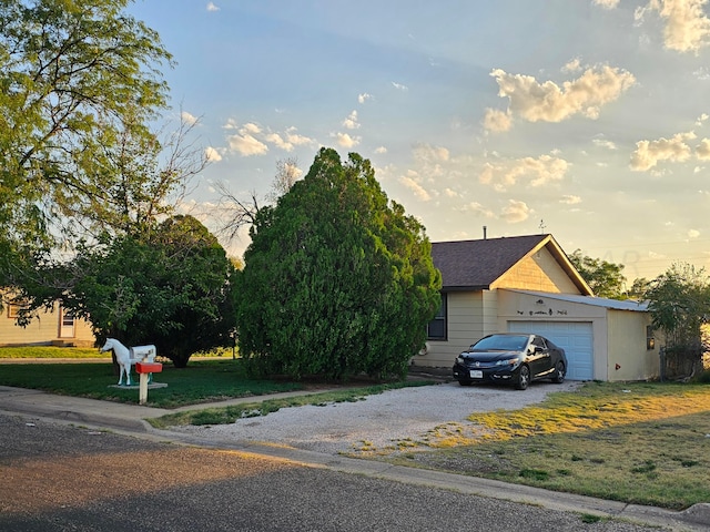 obstructed view of property with a lawn and a garage