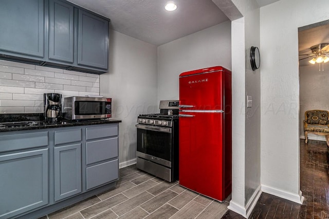 kitchen with ceiling fan, backsplash, appliances with stainless steel finishes, and a textured ceiling