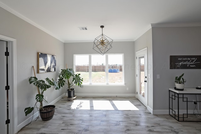 dining area with ornamental molding, light wood-type flooring, and a notable chandelier