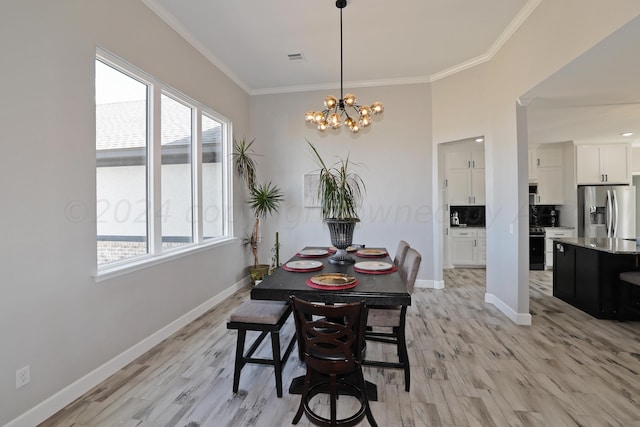 dining area featuring plenty of natural light, light hardwood / wood-style floors, crown molding, and an inviting chandelier