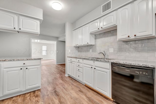 kitchen with visible vents, white cabinets, dishwasher, light stone countertops, and a sink