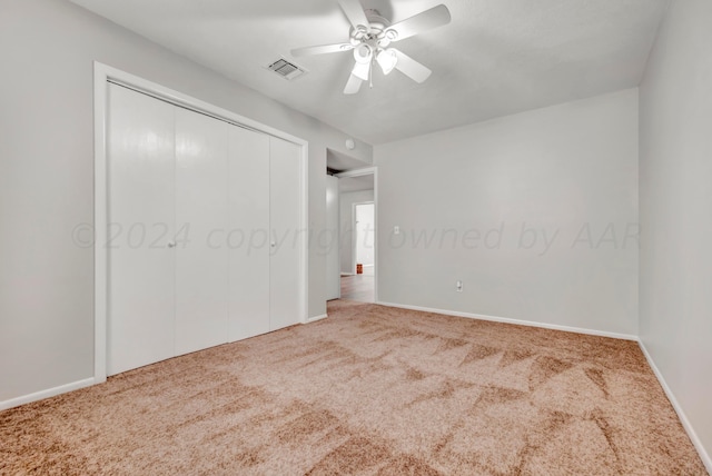 unfurnished bedroom with carpet flooring, visible vents, baseboards, a ceiling fan, and a closet