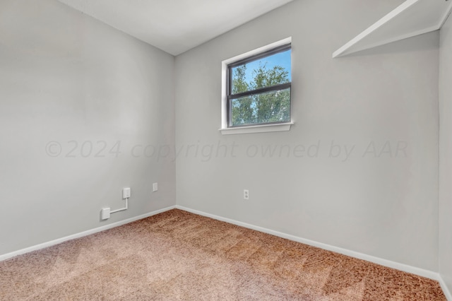 empty room featuring carpet and baseboards