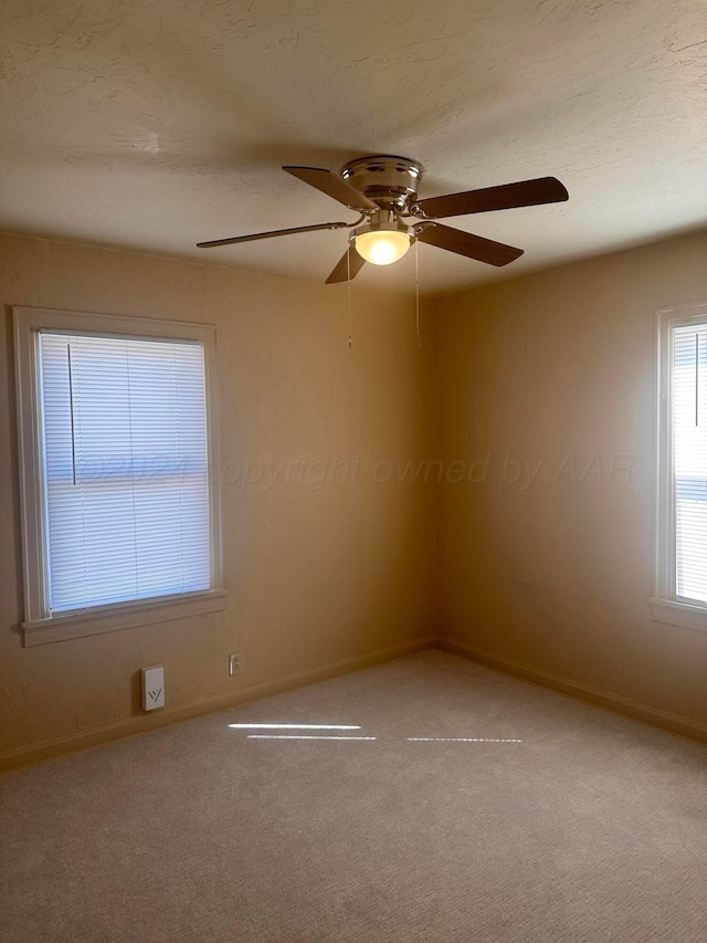 carpeted empty room with baseboards and ceiling fan