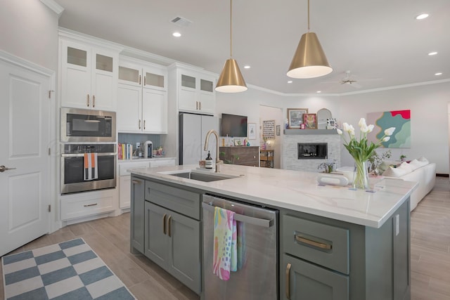 8100 Pensacola Ave, Amarillo, TX 79118 - kitchen with stainless steel appliances, open floor plan, white cabinets, a ceiling fan, and a kitchen island with sink