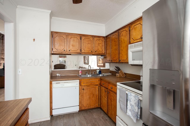 kitchen with ornamental molding, a textured ceiling, dark hardwood / wood-style flooring, sink, and white appliances