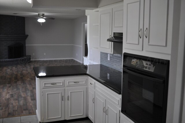 3411 Royal Rd, Amarillo, TX 79109 - kitchen featuring black appliances, a peninsula, exhaust hood, open floor plan, and dark countertops