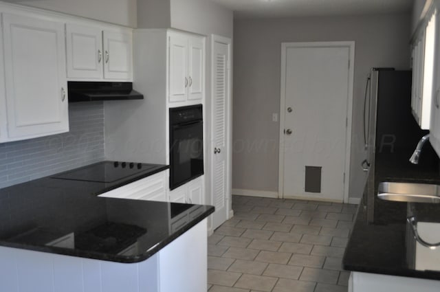 3411 Royal Rd, Amarillo, TX 79109 - kitchen with black appliances, dark countertops, backsplash, under cabinet range hood, and white cabinetry