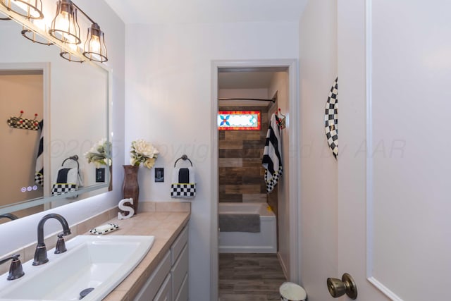 bathroom with a notable chandelier, vanity, and hardwood / wood-style flooring