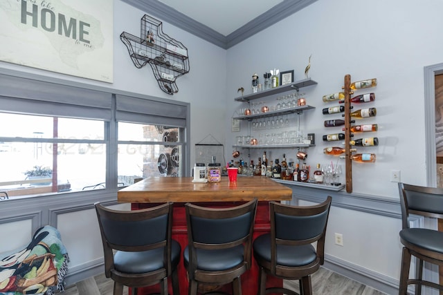 bar with wooden counters, crown molding, and hardwood / wood-style flooring