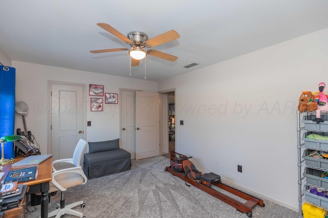 carpeted office space featuring ceiling fan