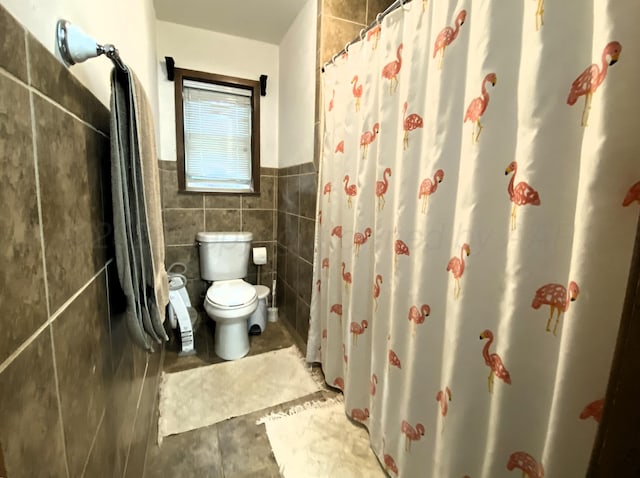 bathroom featuring tile walls, tile patterned floors, and toilet