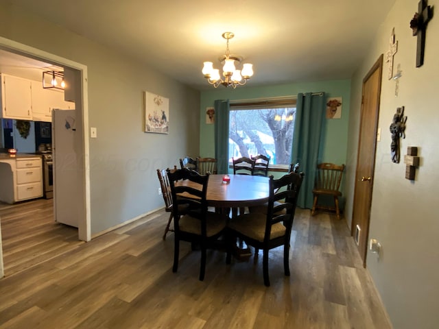 dining space with dark hardwood / wood-style floors and a chandelier