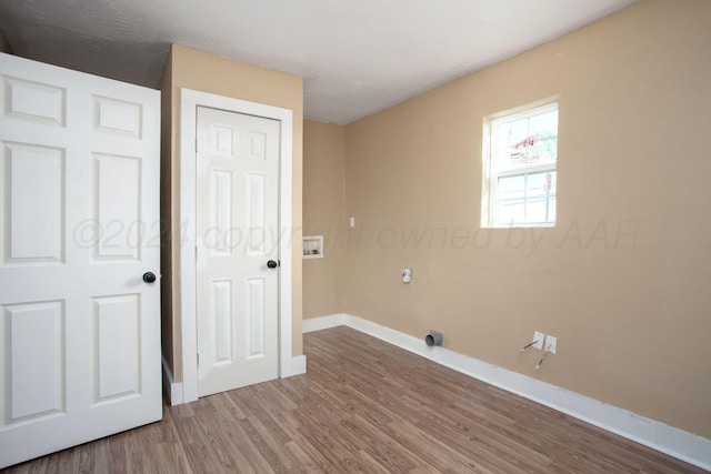 clothes washing area with wood-type flooring