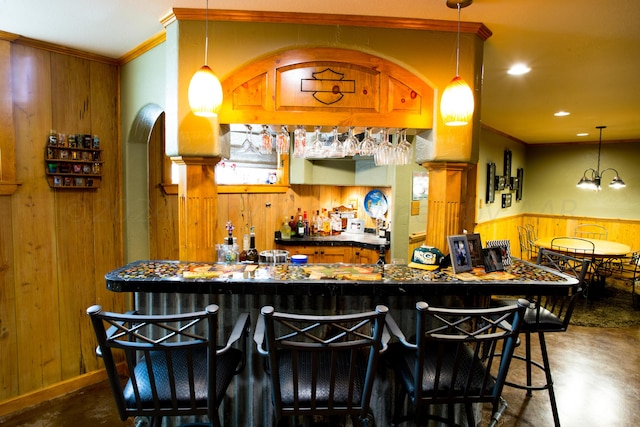 bar with wooden walls, decorative light fixtures, and ornamental molding