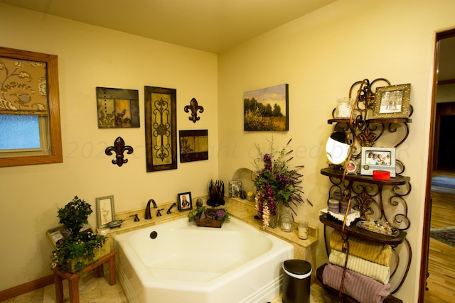 bathroom featuring hardwood / wood-style flooring and a tub to relax in