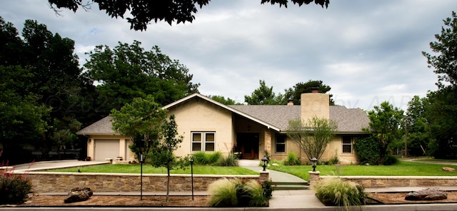 ranch-style house featuring a front yard and a garage