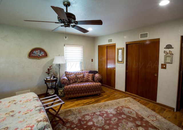 living room featuring wood-type flooring and ceiling fan