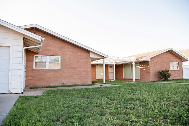 411 E 6th St, Hereford, TX 79045 - view of front facade featuring a front lawn, brick siding, and a garage