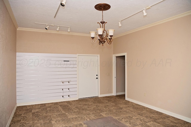 411 E 6th St, Hereford, TX 79045 - empty room featuring track lighting, a chandelier, a textured ceiling, crown molding, and baseboards