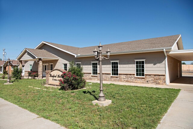 411 E 6th St, Hereford, TX 79045 - view of home's exterior with a lawn, a shingled roof, and stone siding