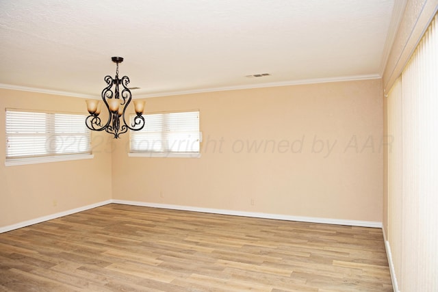 411 E 6th St, Hereford, TX 79045 - spare room featuring ornamental molding, light wood-style flooring, baseboards, and a chandelier