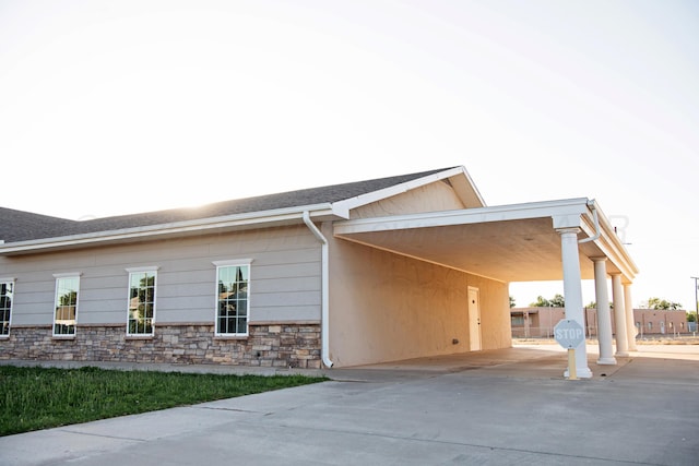 411 E 6th St, Hereford, TX 79045 - view of front of house with concrete driveway, a carport, and stone siding