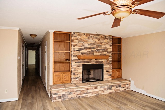 411 E 6th St, Hereford, TX 79045 - unfurnished living room featuring a ceiling fan, a stone fireplace, ornamental molding, baseboards, and wood finished floors